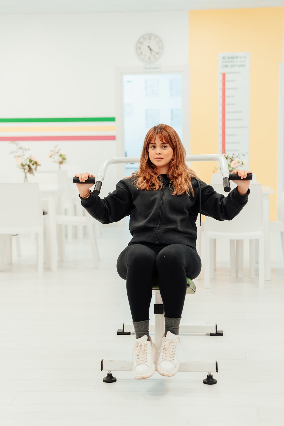 a woman sitting on top of a chair holding a pair of scissors